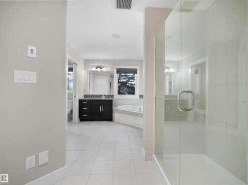 Full bath with a garden tub, a shower stall, light tile patterned floors, and vanity - 59 10550 Ellerslie Road, Edmonton, AB - Indoor Photo Showing Bathroom