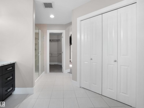 Bathroom featuring a spacious closet, a stall shower, recessed lighting, vanity, and light tile patterned flooring - 59 10550 Ellerslie Road, Edmonton, AB - Indoor