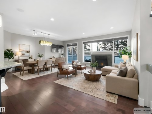 Living room featuring recessed lighting, dark wood-type flooring, and a tile fireplace - 59 10550 Ellerslie Road, Edmonton, AB - Indoor Photo Showing Living Room