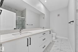 Full bathroom with double vanity, a marble finish shower, and light marble finish flooring - 