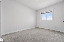 Spare room featuring light colored carpet and baseboards - 