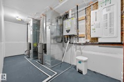 Utility room with electric panel, water heater, and heating unit - 