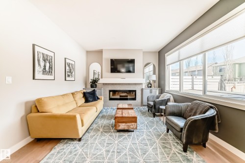 The living area features light-colored walls and hardwood flooring - 11 Etoile Cres N, St. Albert, AB - Indoor Photo Showing Living Room With Fireplace