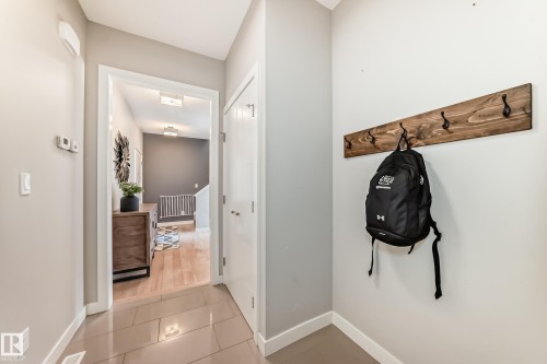 Inviting entryway featuring tile flooring and a wooden coat rack with black hooks - 11 Etoile Cres N, St. Albert, AB - Indoor Photo Showing Other Room
