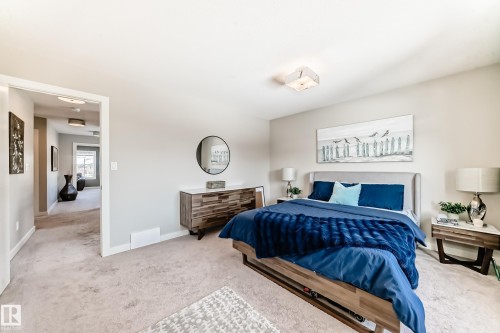 This bedroom features light-colored carpeting, a contemporary light fixture, and a neutral wall color - 11 Etoile Cres N, St. Albert, AB - Indoor Photo Showing Bedroom