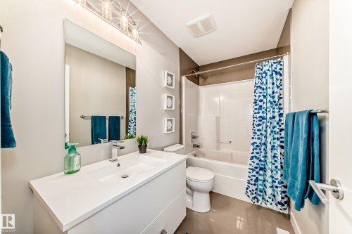 Bathroom featuring a vanity with an integrated sink, a rectangular mirror, and a bathtub with a shower - 11 Etoile Cres N, St. Albert, AB - Indoor Photo Showing Bathroom