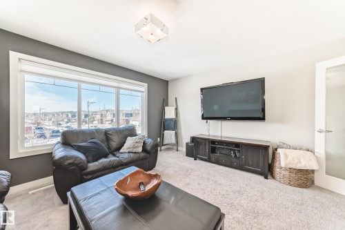 The living room features large windows, providing ample natural light and views of the surrounding neighborhood - 11 Etoile Cres N, St. Albert, AB - Indoor Photo Showing Living Room