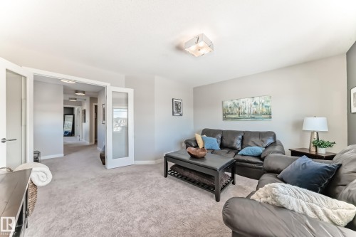Inviting living space featuring light grey walls, carpet flooring, and a contemporary ceiling light fixture - 11 Etoile Cres N, St. Albert, AB - Indoor Photo Showing Living Room