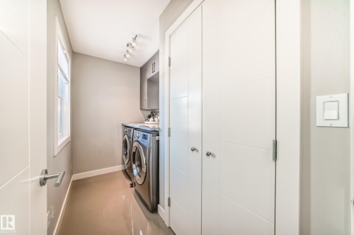 Laundry area featuring a window, track lighting, and built-in cabinetry with a countertop - 11 Etoile Cres N, St. Albert, AB - Indoor Photo Showing Laundry Room