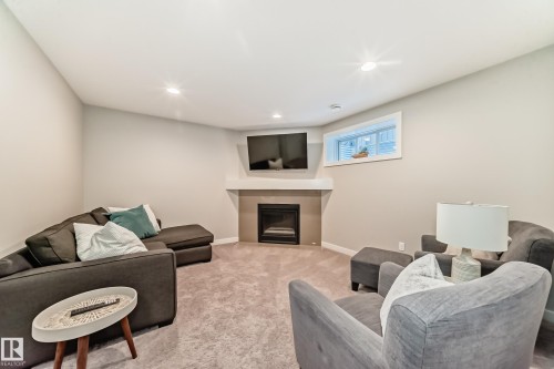 Living area featuring a corner fireplace with a white mantel, a carpeted floor, and recessed lighting - 11 Etoile Cres N, St. Albert, AB - Indoor With Fireplace