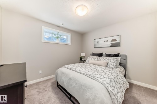 This bedroom features light-colored walls, carpeted floors, and a window providing natural light - 11 Etoile Cres N, St. Albert, AB - Indoor Photo Showing Bedroom