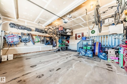 The property features an attached garage with a concrete floor and exposed ceiling beams - 11 Etoile Cres N, St. Albert, AB - Indoor Photo Showing Garage