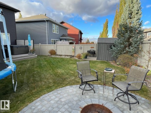 The property features a spacious yard with a lawn, a paved patio area, and a wooden fence - 11 Etoile Cres N, St. Albert, AB - Outdoor