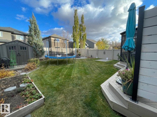 This property features a spacious lawn, a wooden deck with steps, and a raised garden bed - 11 Etoile Cres N, St. Albert, AB - Outdoor