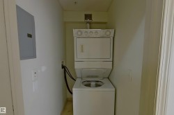 Washroom featuring stacked washer / dryer and electric panel - 