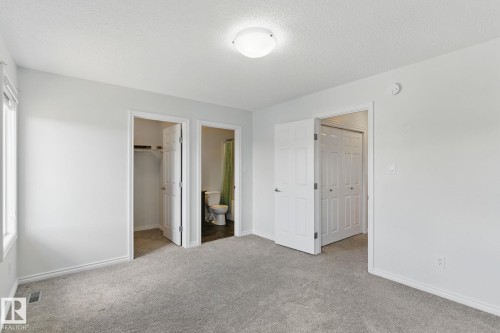 Room featuring light grey carpeting, white walls, and a ceiling-mounted light fixture - 2416 Wonnacott Crest, Edmonton, AB - Indoor