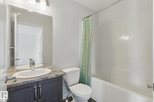 Bathroom featuring a vanity with a countertop and undermount sink, a toilet, and a bathtub with a shower - 2416 Wonnacott Crest, Edmonton, AB - Indoor Photo Showing Bathroom