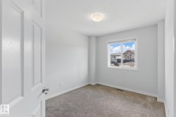 This room features neutral-toned carpet, light gray walls, white trim, and a window providing natural light - 