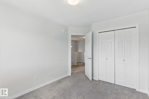This room features light grey walls, grey carpet flooring, and a ceiling light fixture - 2416 Wonnacott Crest, Edmonton, AB - Indoor