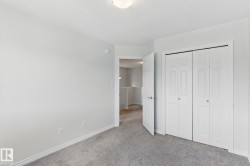 This room features light grey walls, grey carpet flooring, and a ceiling light fixture - 