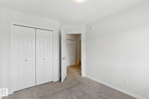 This room features light gray carpeting, white walls, and a ceiling light fixture - 2416 Wonnacott Crest, Edmonton, AB - Indoor