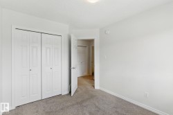 This room features light gray carpeting, white walls, and a ceiling light fixture - 