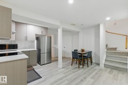 The property features a kitchen area with light wood cabinetry, stainless steel appliances, and light-colored countertops - 