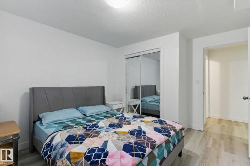 This room features light-colored flooring, a mirrored closet, and a neutral color palette - 2416 Wonnacott Crest, Edmonton, AB - Indoor Photo Showing Bedroom