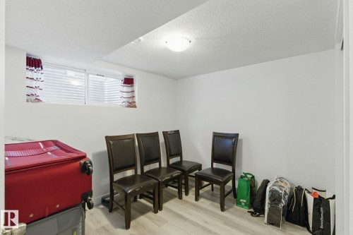 This room features a window with horizontal blinds and decorative curtains, light-colored walls, and a ceiling light fixture - 2416 Wonnacott Crest, Edmonton, AB - Indoor