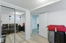 This room features light-colored flooring, white walls, and a sliding mirrored closet door - 