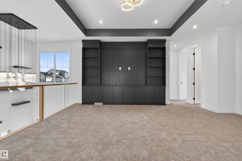 Integrated built-in cabinetry with shelving and beadboard detailing, recessed lighting, and a tray ceiling - 63 Jubilation Drive, St. Albert, AB - Indoor Photo Showing Other Room
