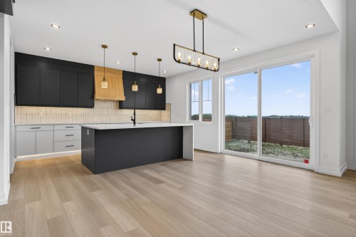 Open-concept living space with light wood-finish flooring - 63 Jubilation Drive, St. Albert, AB - Indoor Photo Showing Kitchen With Upgraded Kitchen