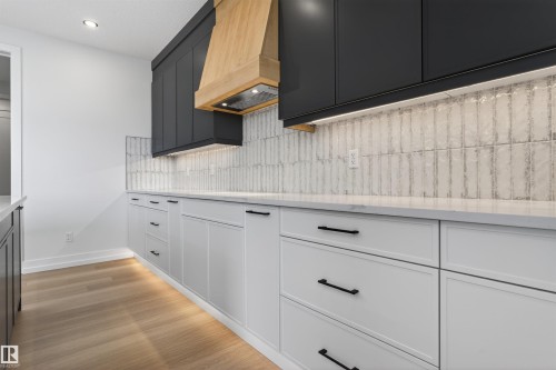 Contemporary kitchen featuring two-tone cabinetry with black upper cabinets and white lower cabinets - 63 Jubilation Drive, St. Albert, AB - Indoor