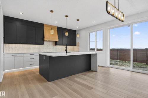 Modern kitchen featuring two-tone cabinetry with black upper cabinets and light lower cabinets, a wood-finish range hood, and a white tile backsplash - 63 Jubilation Drive, St. Albert, AB - Indoor Photo Showing Kitchen With Upgraded Kitchen