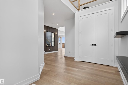 Entryway featuring a pair of double panel doors, light wood-finish flooring, recessed lighting, and dark accent wall paneling - 63 Jubilation Drive, St. Albert, AB - Indoor Photo Showing Other Room