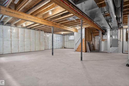 Spacious unfinished basement offering concrete flooring, visible wood joists, exposed structural beams, and foundational insulation - 63 Jubilation Drive, St. Albert, AB - Indoor Photo Showing Basement