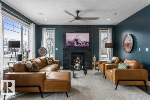 South West Facing Living Room featuring Large Windows, Dark Hard wood Flooring, and Tile Surround Gas Fireplace - 4476 Suzanna Crescent, Edmonton, AB - Indoor Photo Showing Living Room With Fireplace