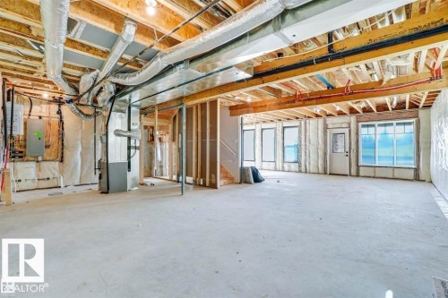 The property features a spacious unfinished basement with exposed wooden beams, ductwork, and structural elements - 47 Rosewood Way, St. Albert, AB - Indoor Photo Showing Basement