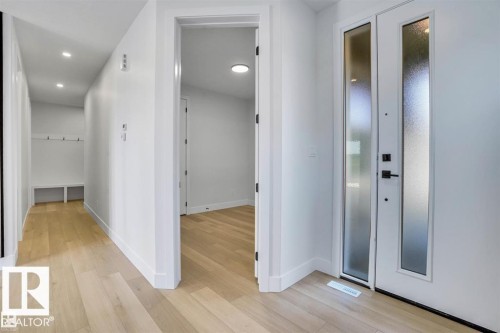 Entryway featuring light-toned hardwood flooring, recessed lighting, and a white front door with frosted glass inserts - 47 Rosewood Way, St. Albert, AB - Indoor Photo Showing Other Room