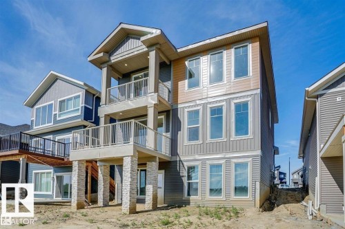 The property features a multi-level design with balconies, a stone pillar foundation, and a mix of siding materials - 47 Rosewood Way, St. Albert, AB - Outdoor With Balcony With Facade