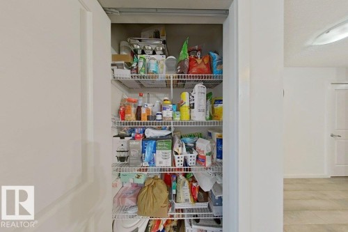 This property includes a pantry with wire shelving, offering practical storage solutions - 429 390 Windermere Rd, Edmonton, AB - Indoor