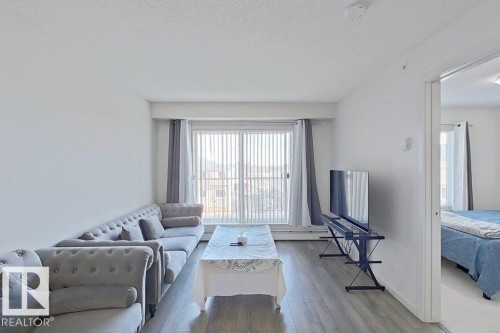 Living area featuring light-colored walls and wood-style flooring - 429 390 Windermere Rd, Edmonton, AB - Indoor Photo Showing Other Room