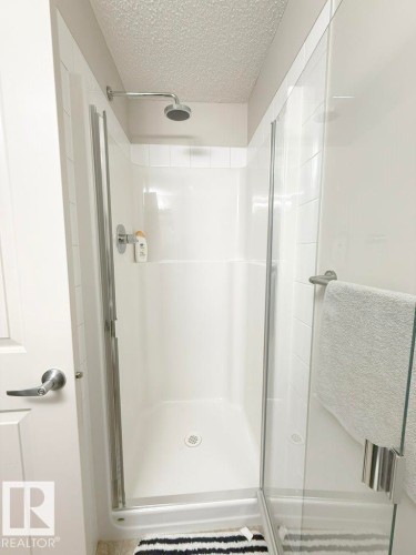 This bathroom features a shower with white subway tile walls and a glass enclosure - 429 390 Windermere Rd, Edmonton, AB - Indoor Photo Showing Bathroom
