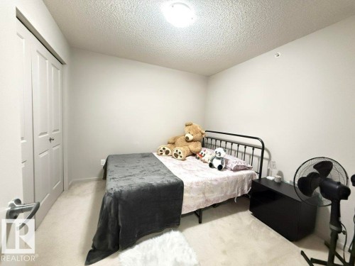 The room features light-colored walls and carpeting, a white bi-fold closet door, and a light fixture on the ceiling - 429 390 Windermere Rd, Edmonton, AB - Indoor Photo Showing Bedroom