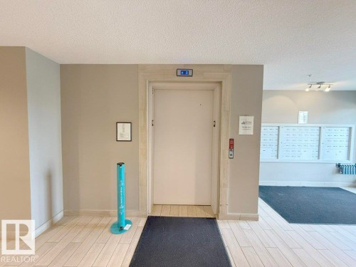 The property features a common area with an elevator, mailboxes, and track lighting - 429 390 Windermere Rd, Edmonton, AB - Indoor Photo Showing Other Room