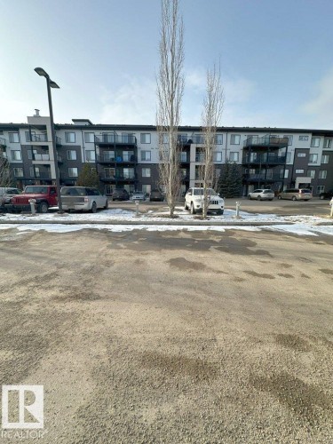 The property features a multi-story building with balconies, set against a clear sky - 429 390 Windermere Rd, Edmonton, AB - Outdoor