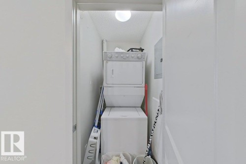 Dedicated laundry area featuring a stacked washer and dryer - 429 390 Windermere Rd, Edmonton, AB - Indoor Photo Showing Laundry Room