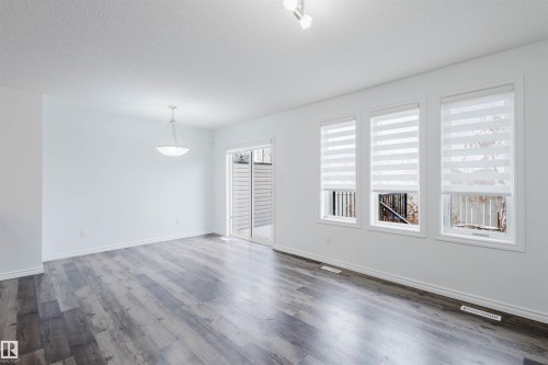 Spare room with dark wood-type flooring and a textured ceiling - Edmonton, AB - Indoor Photo Showing Other Room