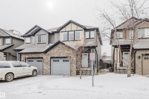 View of front of home featuring stone siding and a garage - Edmonton, AB - Outdoor With Facade