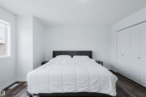 Bedroom with a closet and dark wood-type flooring - Edmonton, AB - Indoor Photo Showing Bedroom